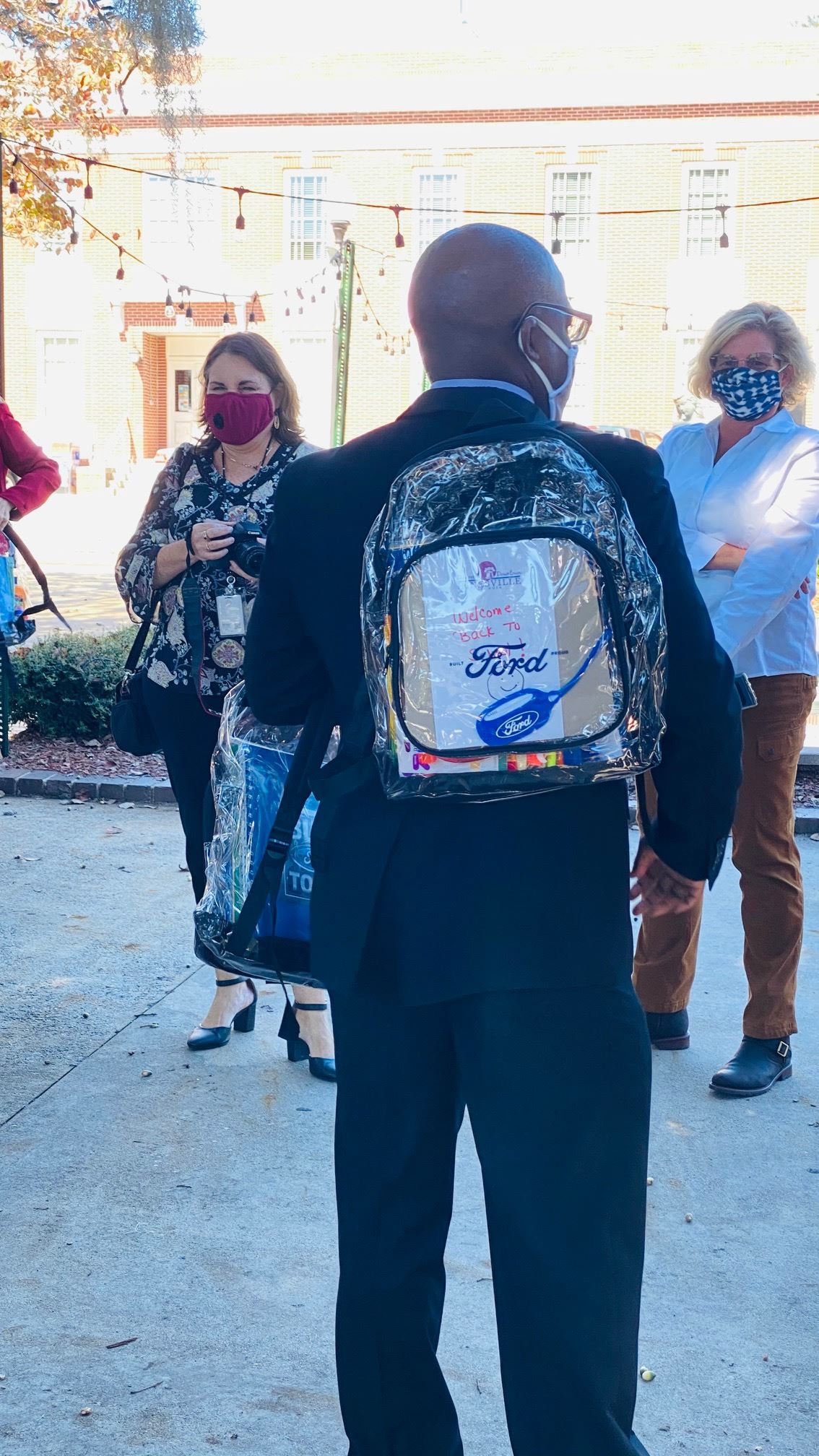 Hinesville District 5 Councilman Karl Riles wears carries a backpack to be given to a student